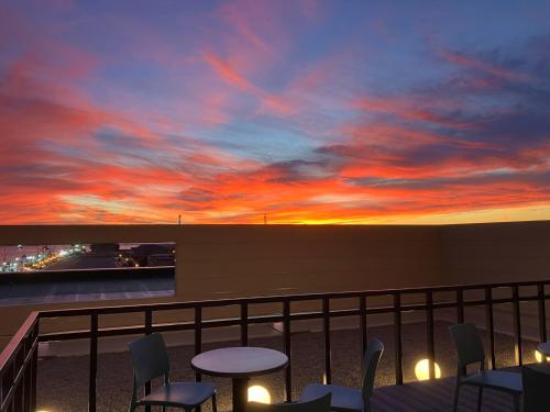 a sunset on a balcony with tables and chairs at ANA Crowne Plaza Hotel Kushiro by IHG in Kushiro