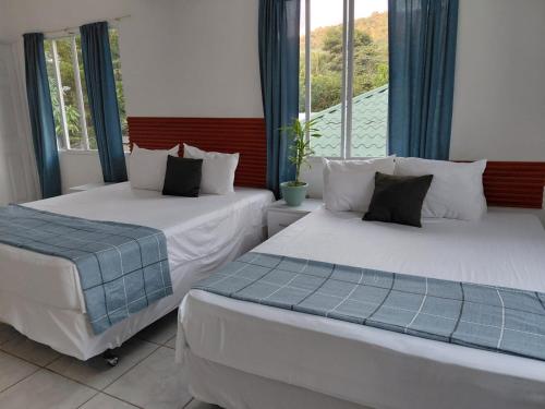 twee bedden in een kamer met een raam bij Jardín Escondido in La Libertad