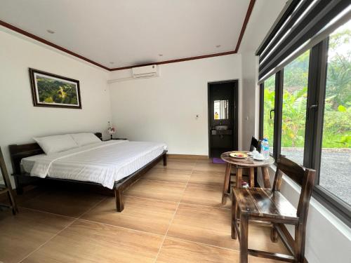 a bedroom with a bed and a table at Tam Coc Mountain Light Homestay in Ninh Binh