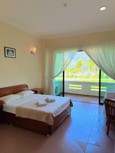 a bedroom with a bed and a large window at Met Blue Ocean Resort in Mersing