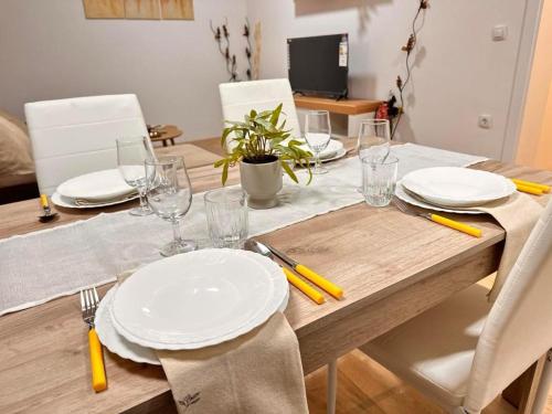 a wooden table with white plates and glasses on it at La Casa 2 in Sombor