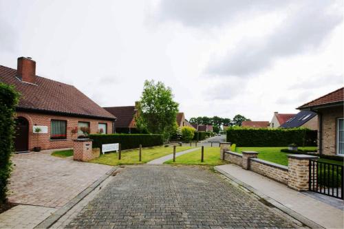 a cobblestone street in a residential neighborhood with houses at B&B Woodside in Torhout