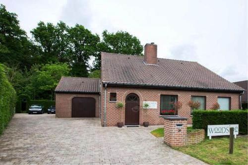 a brick house with a driveway in front of it at B&B Woodside in Torhout