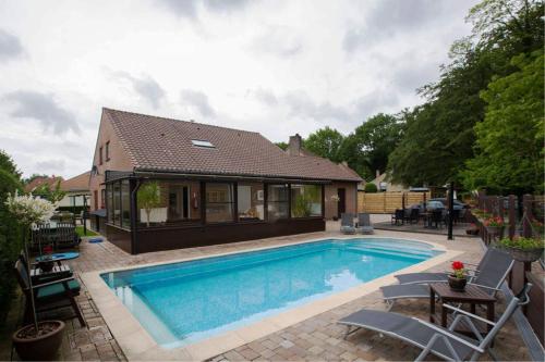 a swimming pool in the backyard of a house at B&B Woodside in Torhout