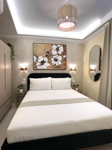 a bedroom with a large white bed and a painting at Rosalina Residences in Birkirkara