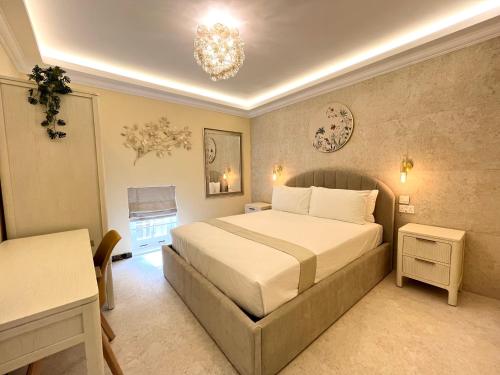 a bedroom with a bed and a table and a chandelier at Rosalina Residences in Birkirkara