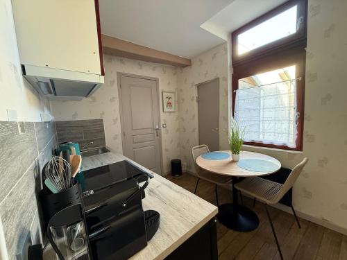 een keuken met een tafel en een kleine tafel. bij Parenthèse Champenoise T23 in Troyes