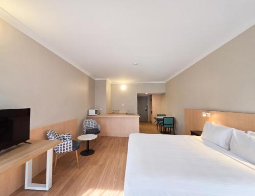 a hotel room with a bed and a television at El Toro Motel in Warwick Farm