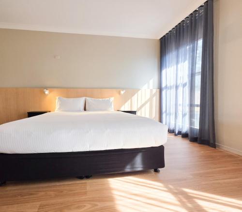 a bedroom with a large bed and a large window at El Toro Motel in Warwick Farm