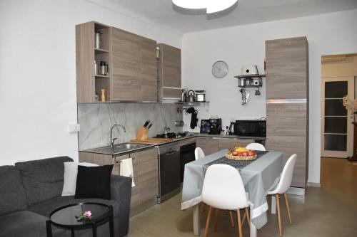 Una cocina y una sala de estar con una mesa y un sofá. en Casa Grace Relax nel cuore del Monferrato, en Casale Monferrato