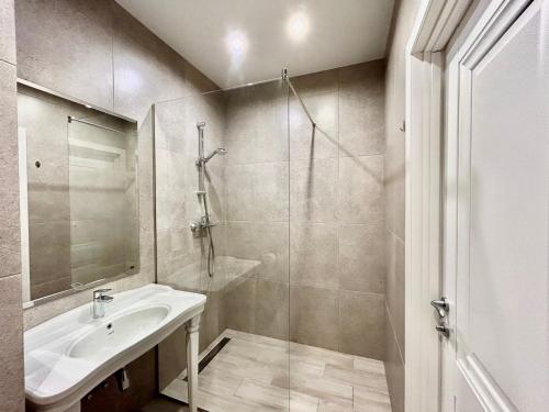 a bathroom with a sink and a glass shower at Designer luxury Appartment in Kharkiv
