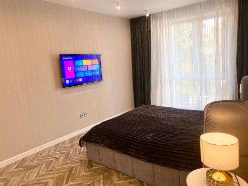a bedroom with a bed and a tv on the wall at Designer luxury Appartment in Kharkiv