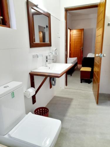 a bathroom with a sink and a toilet and a mirror at Tusker Home stay in Sri Jayewardenepura Kotte
