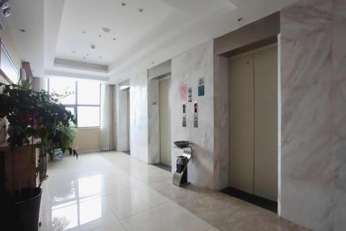 a large room with white marble walls and a hallway at City Comfort Inn Jingzhou Ancient City Taiyue Road in Caoshi