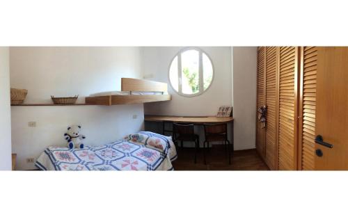 a bedroom with a bed and a table and a window at Villa sull'Acqua in Sabaudia