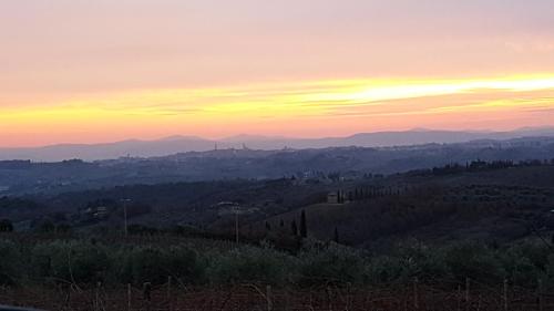 a view of a sunset from a hill with trees at Dimora nel Chianti in San Sano