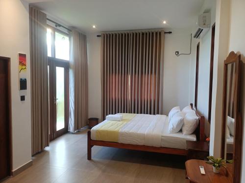 een slaapkamer met een bed en een groot raam bij Paddy Edge Ahangama in Ahangama