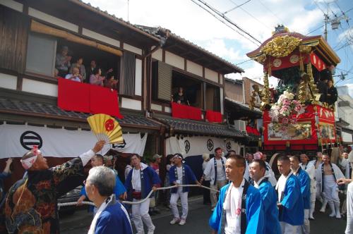 a man holding a flag in front of a crowd of people at Calendar Hotel in Otsu