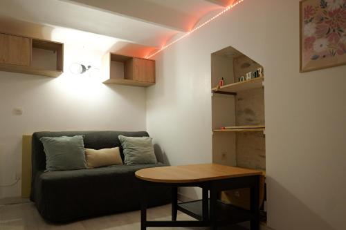 een woonkamer met een bank en een tafel bij Charmant studio cœur de ville et proche plage in Les Sables-dʼOlonne