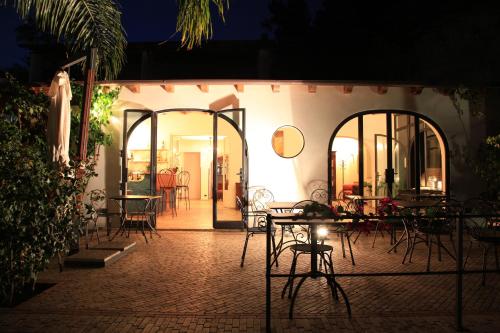 an outdoor patio with tables and chairs at night at Hotel Villa Enrica - Aeolian Charme in Lipari