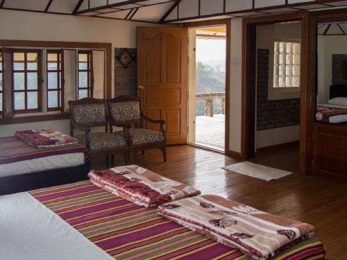 een kamer met 2 bedden en een glazen schuifdeur bij Lei Thar Gone Guest House in Yenangyaung