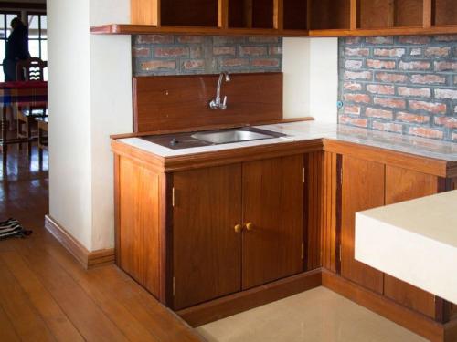 a kitchen with wooden cabinets and a sink at Lei Thar Gone Guest House in Yenangyaung