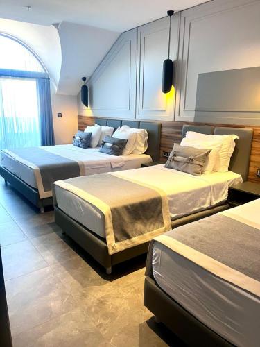 a hotel room with two beds and a window at TELMESSOS CİTY HOTEL- Adults Only in Fethiye