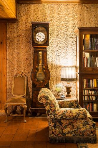 a living room with a grandfather clock and a chair at Hotel Hermitage Relais & Châteaux in Breuil-Cervinia