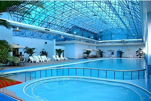 a large swimming pool in a building with a ceiling at Dolton Hotel Changsha in Changsha