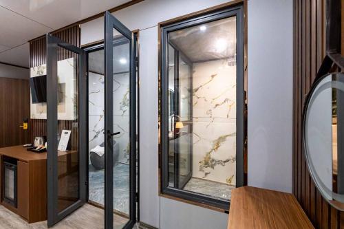 万象Champa Phan Boutique Hotel的一间有玻璃窗的房间，里面有一张带镜子的桌子。
