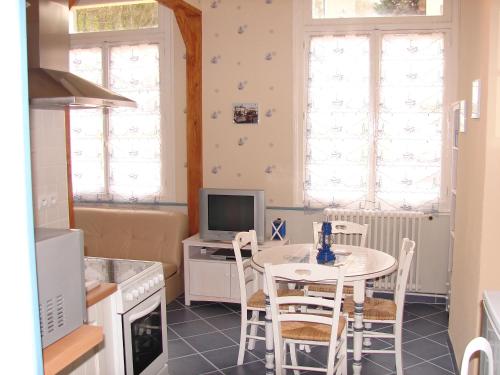 a kitchen with a table with chairs and a computer at Studio à St Pierre en Port in Saint-Pierre-en-Port