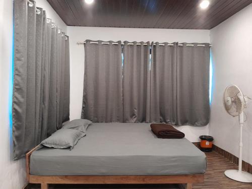 a bed in a room with a curtain at Mountain Vista Vagamon in Vagamon
