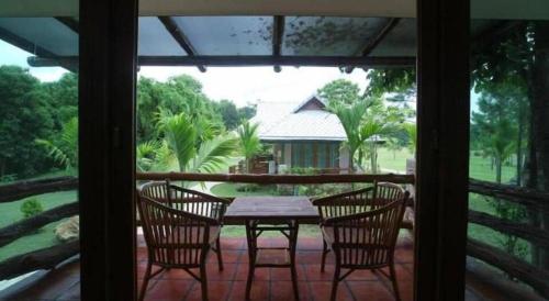 Chiangkham Luang Resort في Ban Huai Sai: فناء على طاولة وكراسي على شرفة