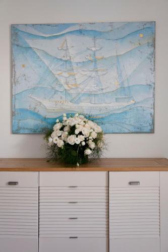 a vase of flowers sitting on top of a dresser at Hotel Amarea - Aeolian Charme in Canneto