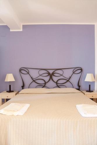a bedroom with a large bed with a purple wall at Hotel Amarea - Aeolian Charme in Canneto