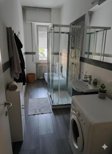 a bathroom with a shower and a sink and a washing machine at Residence Appartamenti Casa Vacanze Abbazia in Pesaro