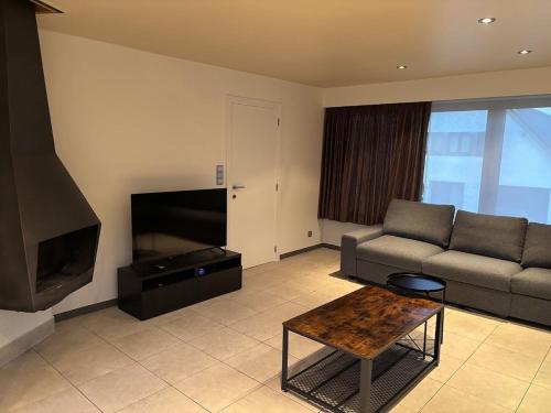 una sala de estar con un sofá y una mesa en Holiday home in Bredene space & fun by the sea, en Bredene