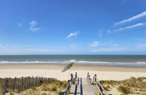 un paseo marítimo de madera que conduce a una playa con el océano en Holiday home in Bredene space & fun by the sea, en Bredene