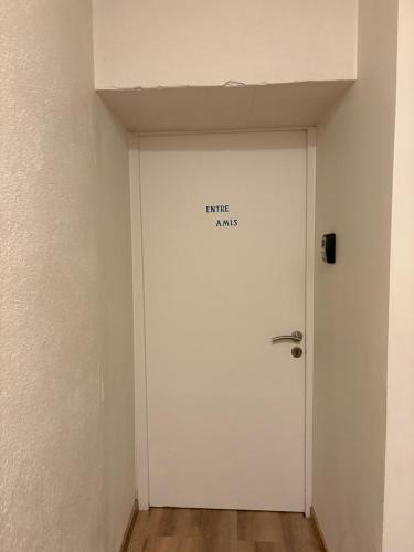 a white door with a sign on it in a room at Les Glaneuses gîte Entre Amis centre-bourg à 3 min du Puy duFou in Les Épesses