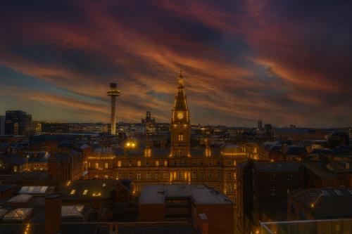 Sidemersey Livings- Unmatched Panoramic Views, Secure Parking, Beautiful Balcony- A Stay to Remember في ليفربول: اطلالة على مبنى مع برج الساعة ليلا