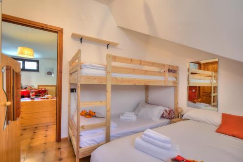 a bedroom with two bunk beds and a mirror at Appartamento Nido Alpino - Happy Rentals in Souchères Basses