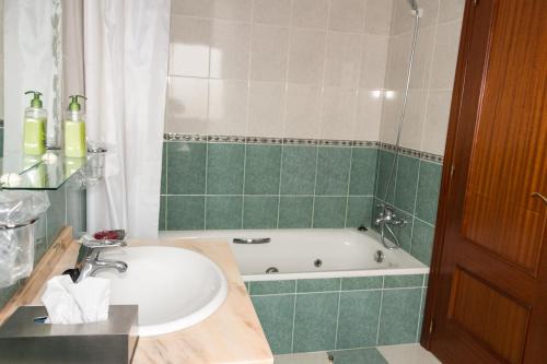 y baño con lavabo y bañera. en Hotel Avenida III, en Villadangos del Páramo