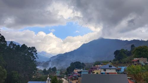 a view of a city with a mountain in the background at MistyKera in Vattavada