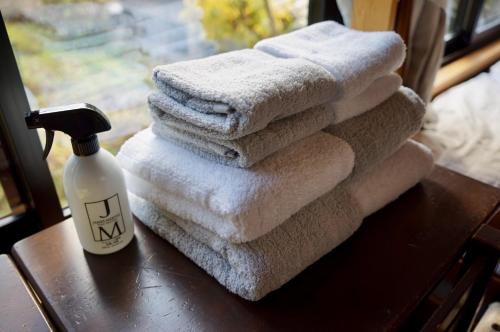 Sakura House サクラハウス 高知駅から車で20分-豊かな自然を味わう山の隠れ家 في كوتشي: كومة من المناشف على طاولة مع زجاجة من الصابون