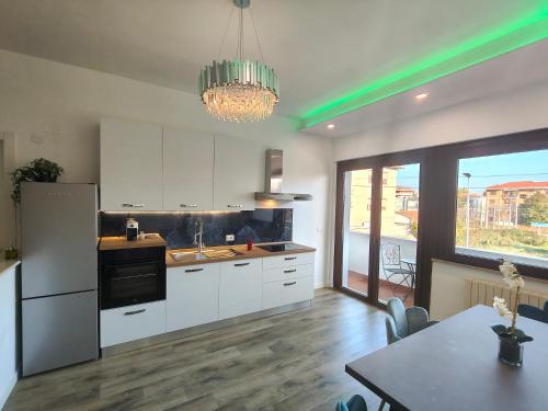 une cuisine avec des placards blancs, une table et un lustre dans l'établissement Suite il Sogno, à Francavilla al Mare