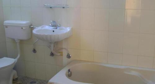 a bathroom with a sink and a tub and a toilet at Mystique Highland Resort in Astam