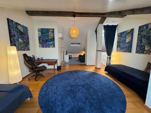a living room with a blue rug and a bedroom at Top floor Marina Duplex in Vila Franca do Campo