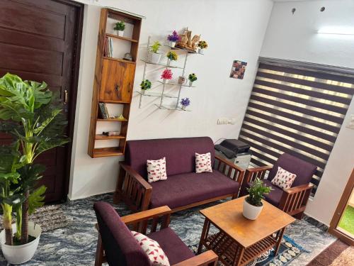 een woonkamer met een bank, stoelen en een tafel bij White coral beach home in Alleppey