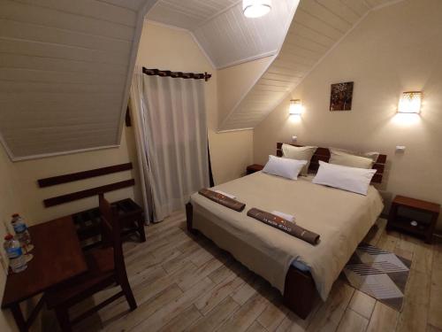 una camera da letto con un letto, un tavolo e una scrivania di La Maison Betsileo a Fianarantsoa