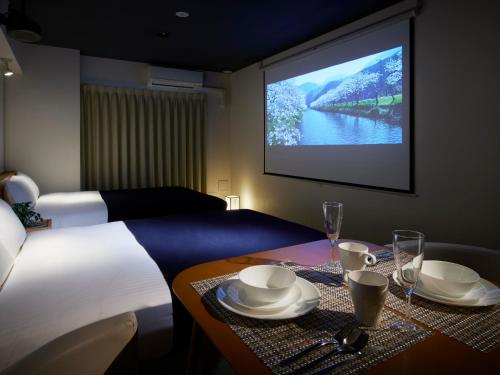 a hotel room with a bed and a flat screen tv at Minn Shin-Osaka in Osaka